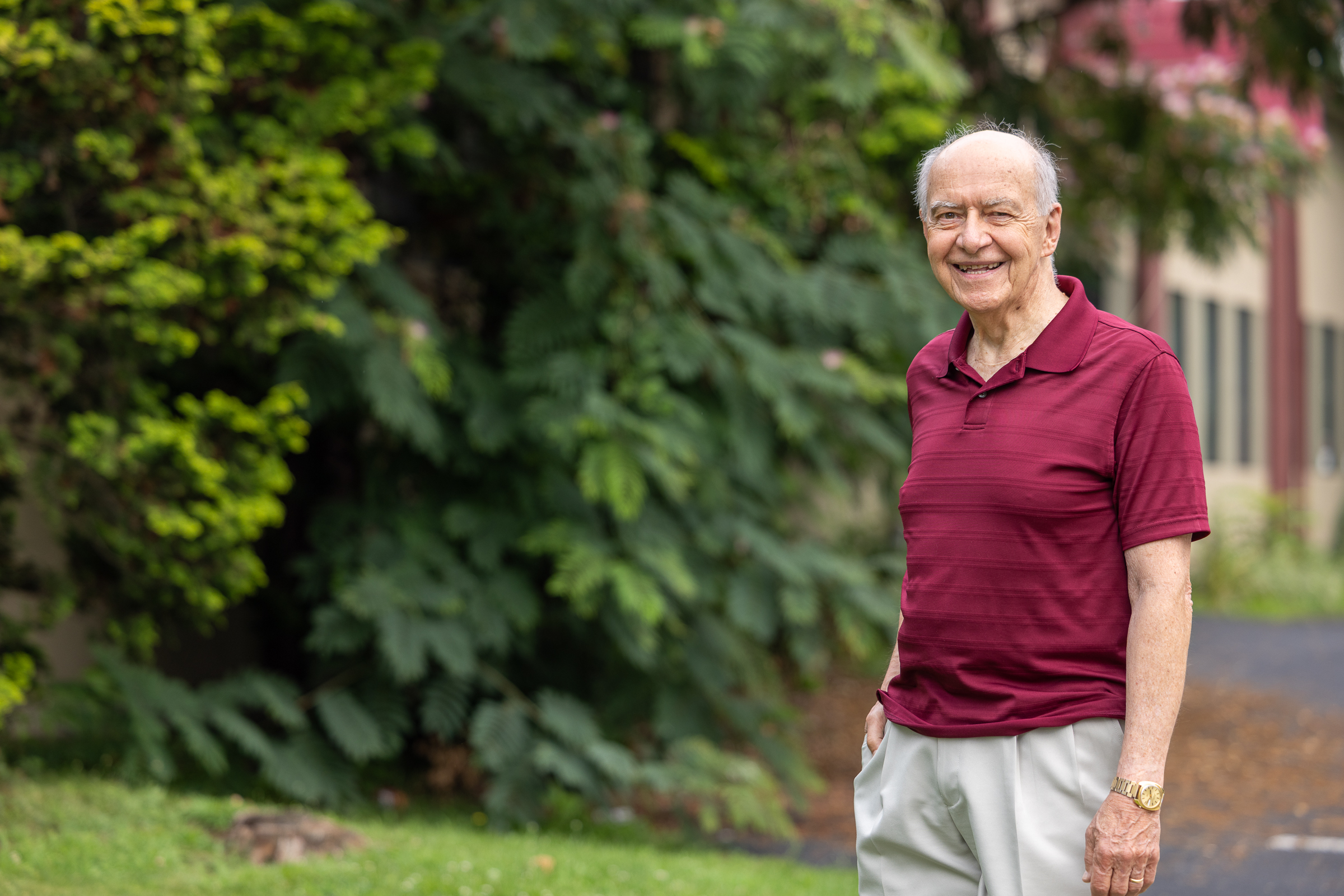 Older adult smiling in a casual portrait, shown in a relaxed setting with a soft background.